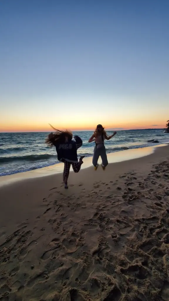 Guests walking on the beach during a CARI event at sunset, enjoying the view.
