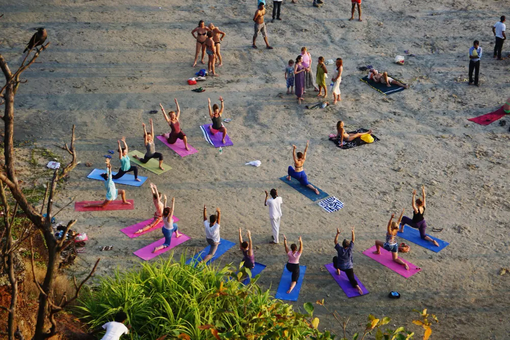 Group yoga session on the beach during a wellness retreat at CARI private waterfront resort