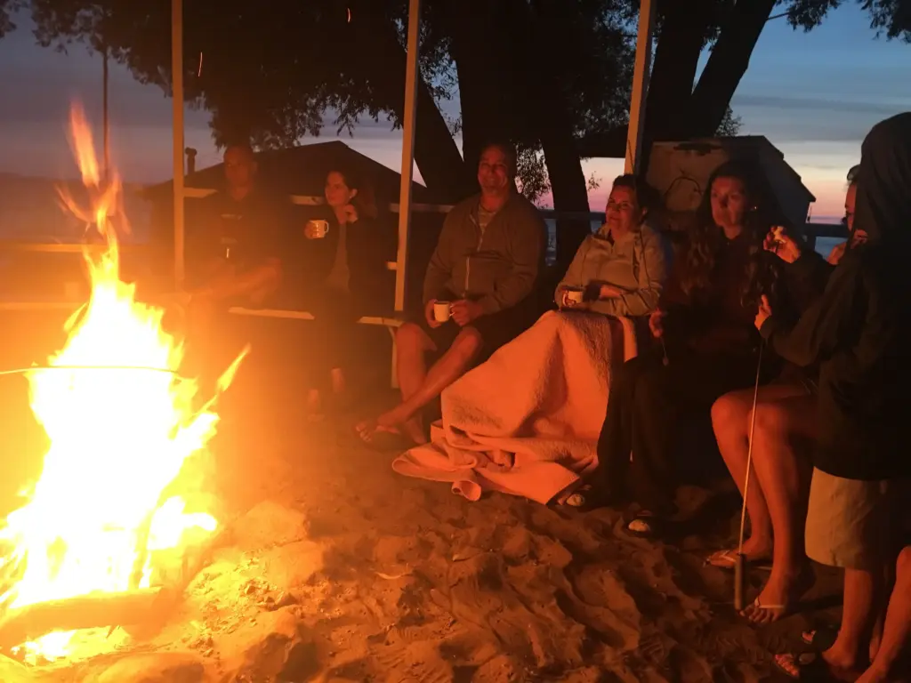 Cozy beach bonfire at night, a relaxing social moment for a CARI event or retreat.