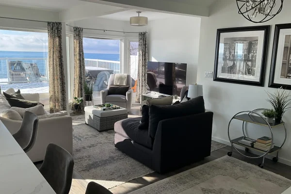 Comfortable lounge and dining area with waterfront views at CARI resort for retreats and celebrations